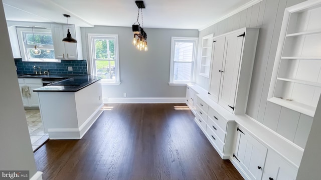 kitchen featuring decorative light fixtures, white cabinets, and built in features