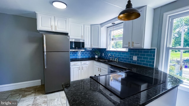 kitchen featuring decorative light fixtures, white cabinets, and appliances with stainless steel finishes