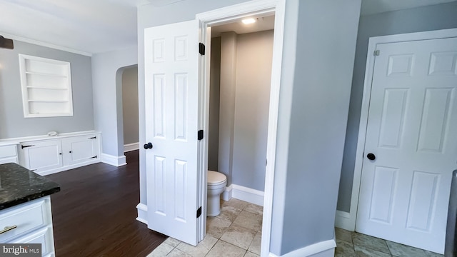 bathroom with toilet, vanity, and built in features