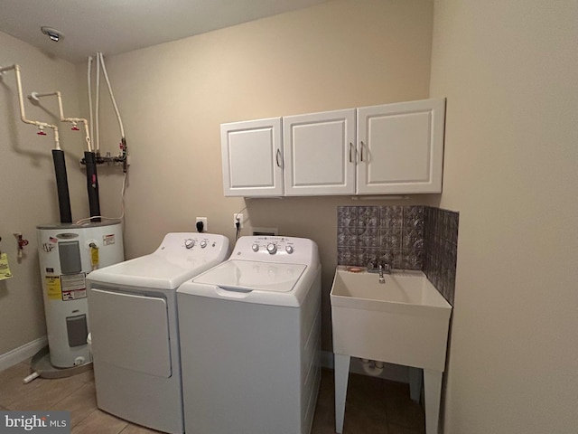 laundry area with light tile patterned floors, sink, cabinets, electric water heater, and independent washer and dryer