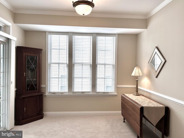 sitting room with ornamental molding and light carpet