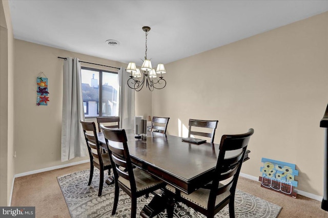 carpeted dining room with an inviting chandelier