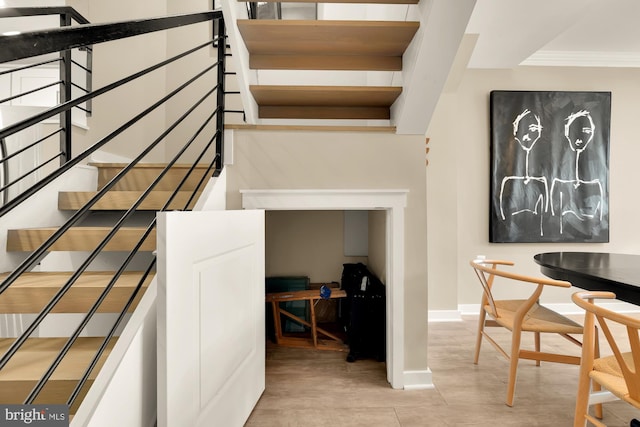 stairs featuring hardwood / wood-style flooring and ornamental molding