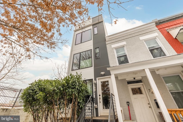 townhome / multi-family property featuring brick siding and fence