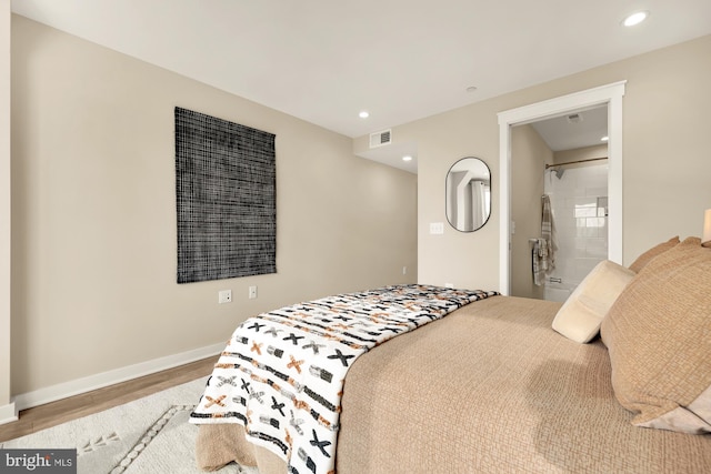 bedroom featuring wood-type flooring and ensuite bath