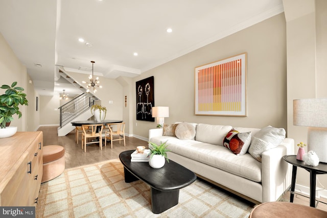 living room featuring a notable chandelier, crown molding, and wood-type flooring