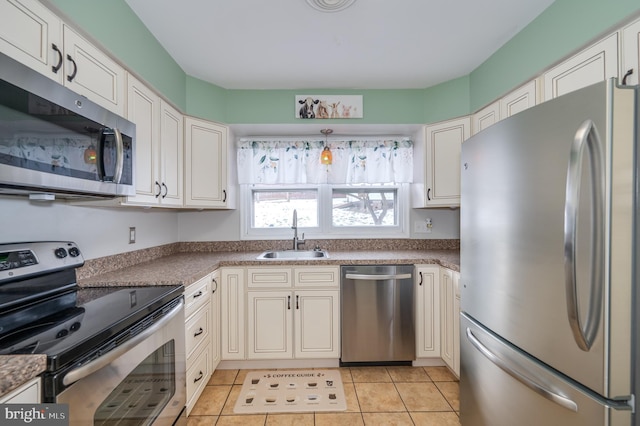 kitchen with white cabinets, light tile patterned floors, appliances with stainless steel finishes, and sink