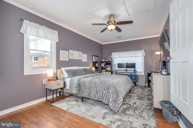 bedroom with ceiling fan, hardwood / wood-style flooring, and ornamental molding