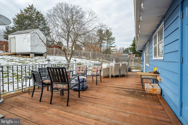 snow covered deck featuring a shed