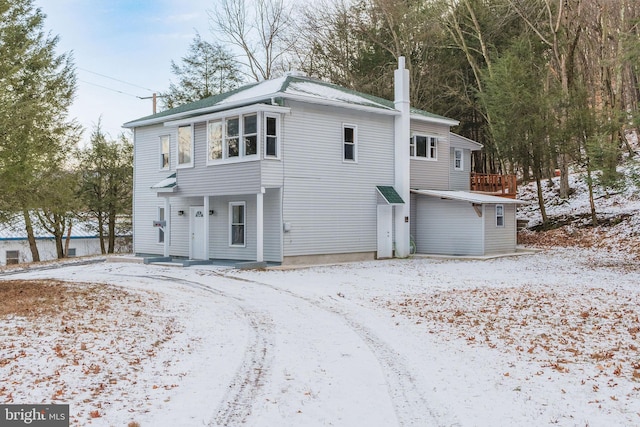 view of snow covered rear of property