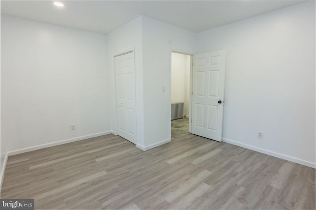 unfurnished bedroom with a closet and light wood-type flooring