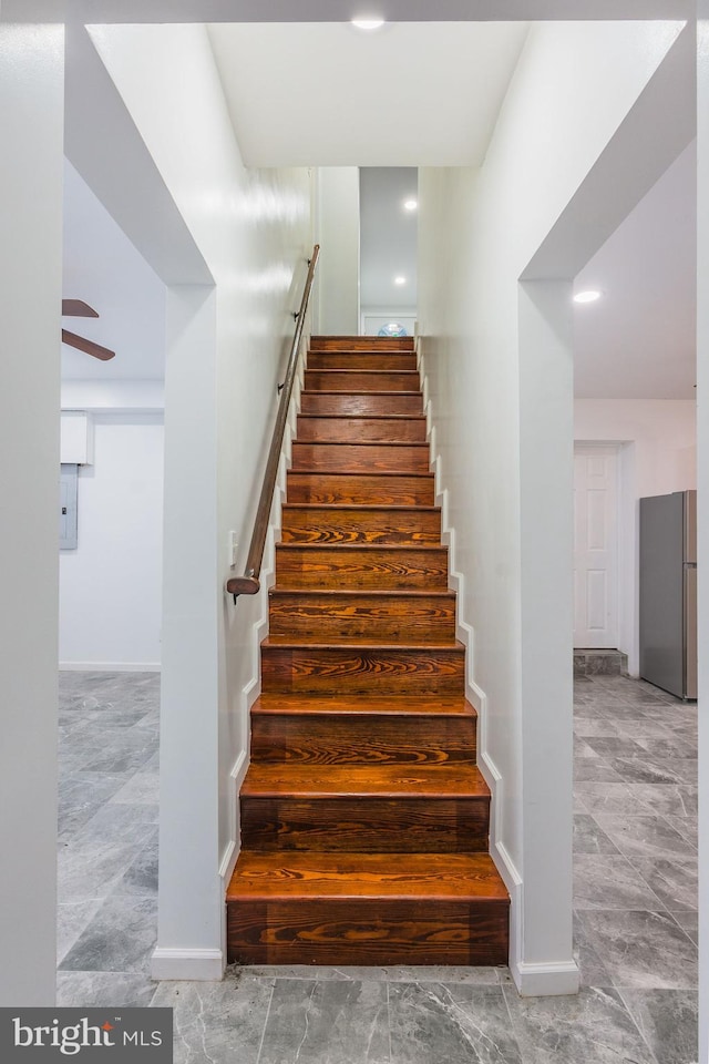 staircase featuring ceiling fan