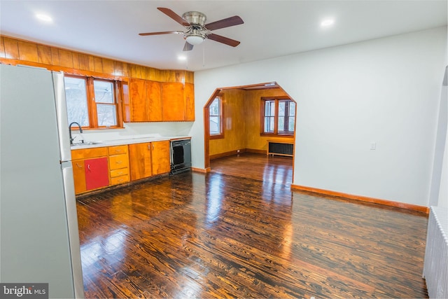 kitchen featuring sink, stainless steel refrigerator, radiator heating unit, dark hardwood / wood-style flooring, and dishwasher