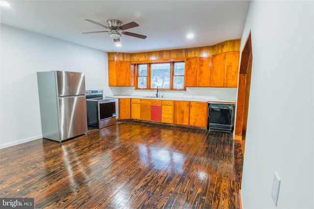 kitchen with appliances with stainless steel finishes, sink, dark wood-type flooring, and ceiling fan