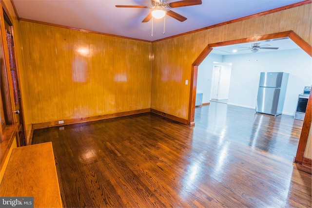 spare room with wooden walls, dark hardwood / wood-style floors, and ceiling fan