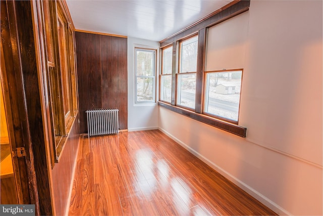 unfurnished room featuring hardwood / wood-style flooring and radiator