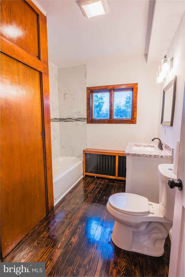 bathroom with hardwood / wood-style flooring, vanity, radiator, and toilet