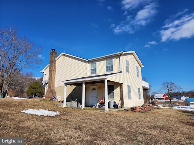 back of property featuring a lawn