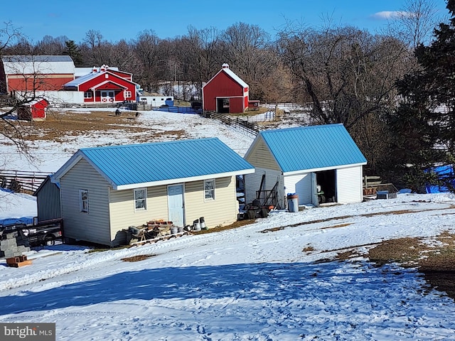 snow covered rear of property with an outdoor structure