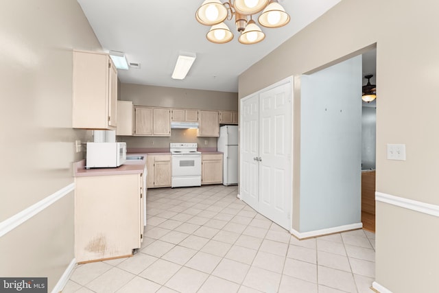 kitchen with an inviting chandelier, light tile patterned floors, and white appliances