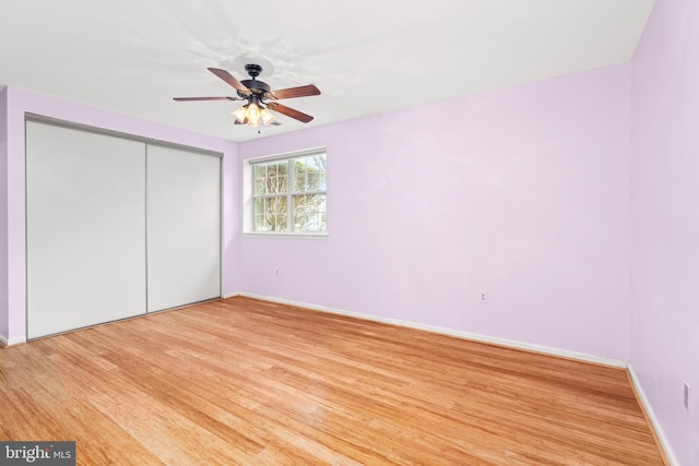 unfurnished bedroom with ceiling fan, hardwood / wood-style floors, and a closet