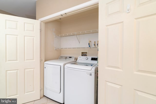 laundry area with washing machine and dryer and light tile patterned flooring