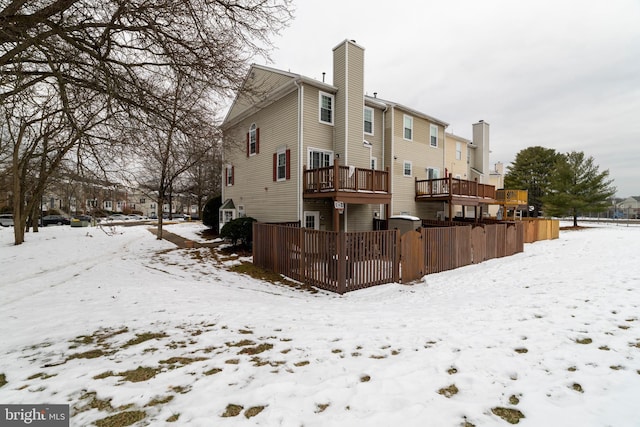 snow covered property with a deck