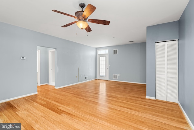 empty room with ceiling fan and light hardwood / wood-style flooring