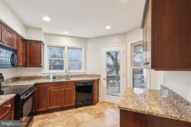 kitchen with light stone countertops, sink, and black appliances