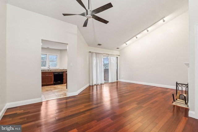 unfurnished living room featuring vaulted ceiling, sink, ceiling fan, and light hardwood / wood-style flooring