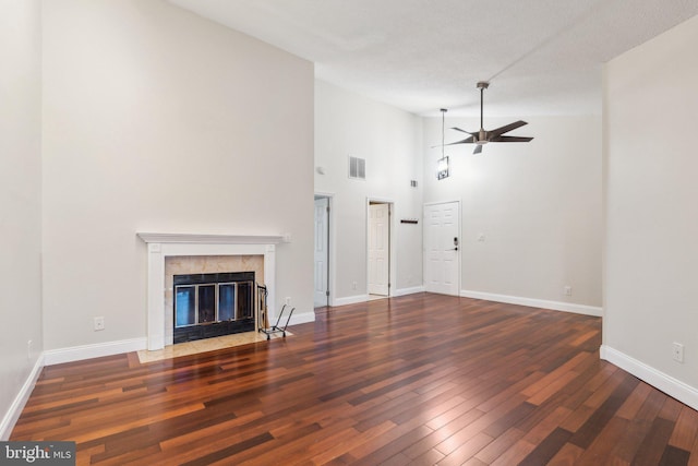 unfurnished living room with ceiling fan, high vaulted ceiling, dark wood-type flooring, and a fireplace