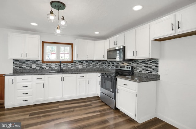 kitchen featuring white cabinetry, appliances with stainless steel finishes, sink, and decorative light fixtures