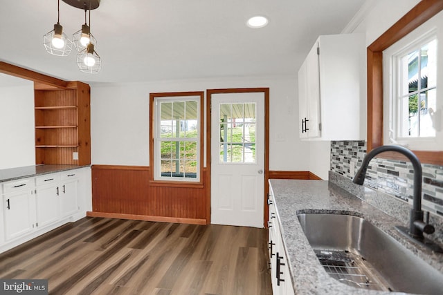 kitchen with pendant lighting, sink, dark wood-type flooring, stone counters, and white cabinets