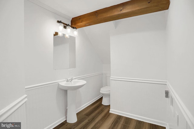 bathroom featuring hardwood / wood-style floors, beamed ceiling, sink, and toilet