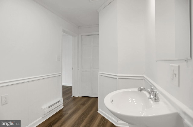 bathroom with a baseboard radiator, ornamental molding, sink, and hardwood / wood-style floors