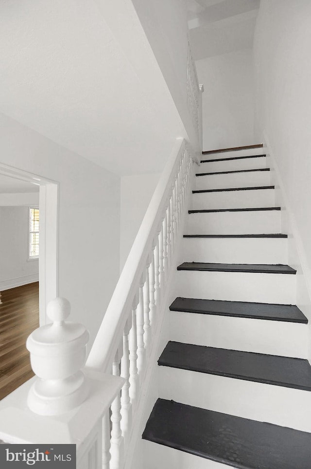 staircase with hardwood / wood-style flooring