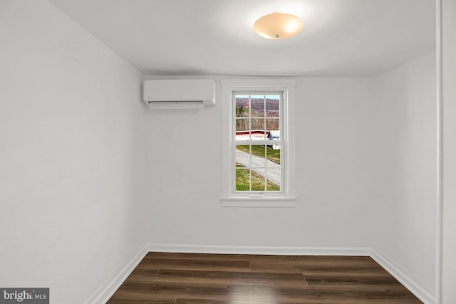 empty room featuring dark wood-type flooring and an AC wall unit