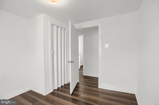 hallway with dark hardwood / wood-style flooring