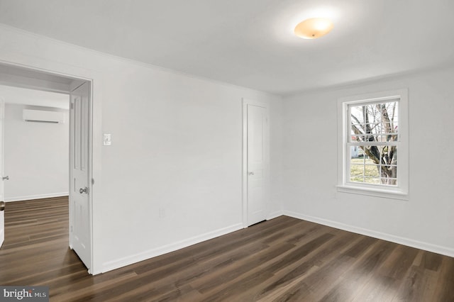 unfurnished room with dark wood-type flooring and a wall mounted AC