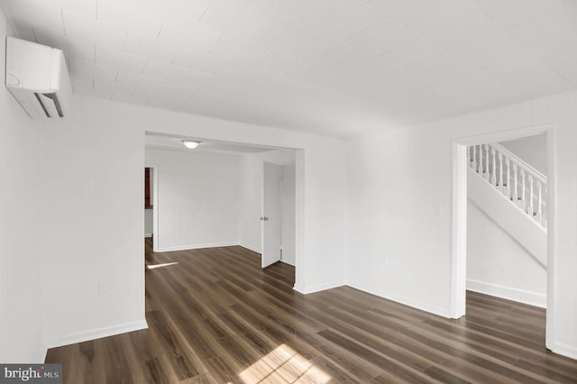 empty room featuring dark hardwood / wood-style floors and a wall mounted AC