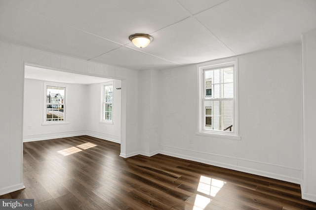 unfurnished room with dark wood-type flooring