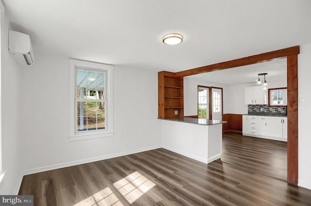 interior space with dark wood-type flooring and a wall unit AC