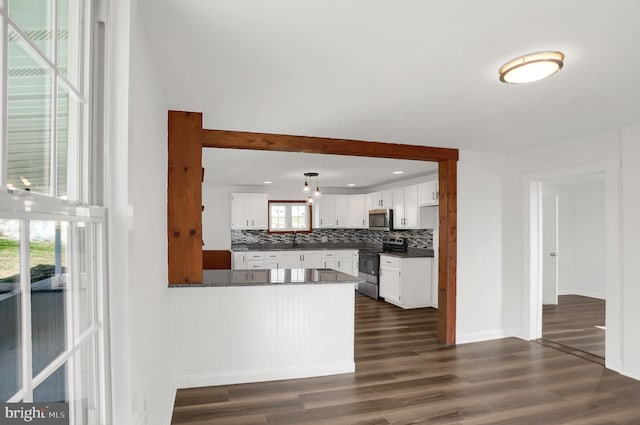 kitchen featuring dark hardwood / wood-style floors, tasteful backsplash, white cabinetry, kitchen peninsula, and stainless steel appliances