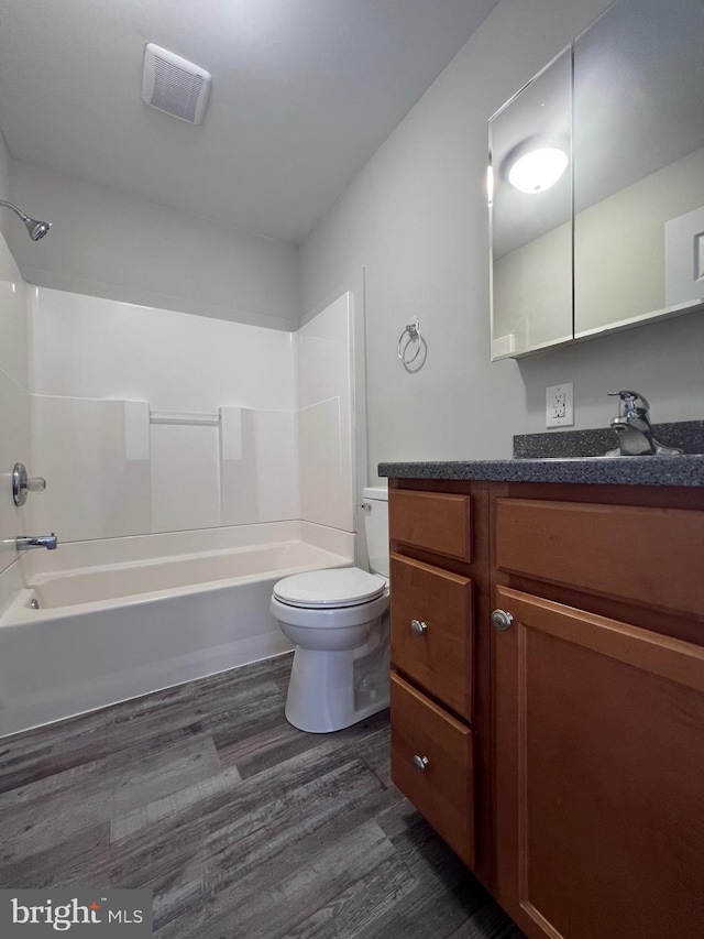 full bathroom featuring hardwood / wood-style floors, toilet, vanity, and shower / tub combination