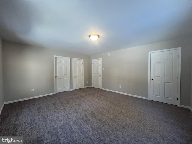 spare room featuring dark carpet