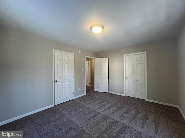 unfurnished bedroom featuring dark colored carpet