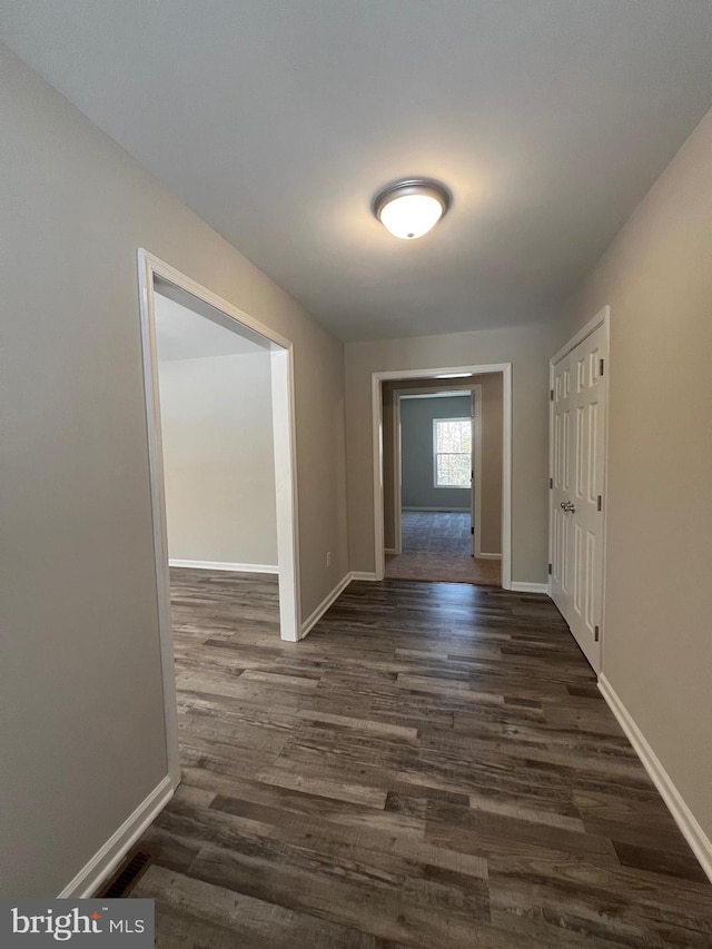 hallway with dark hardwood / wood-style flooring