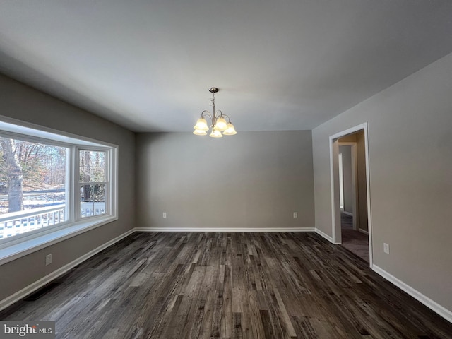 unfurnished dining area featuring dark hardwood / wood-style floors and an inviting chandelier