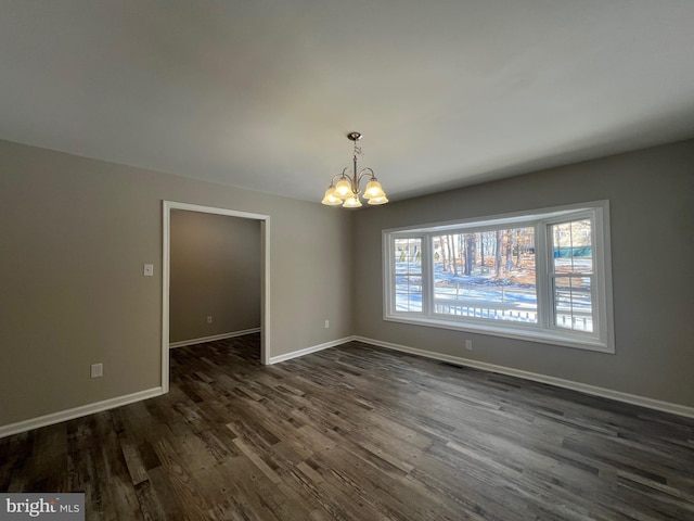 unfurnished room with dark wood-type flooring, plenty of natural light, and a chandelier