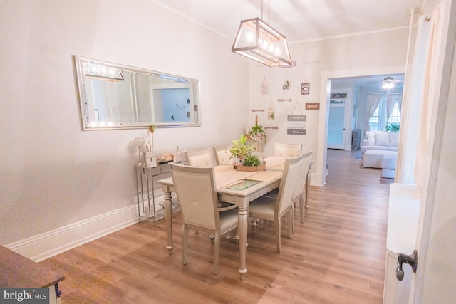 dining space featuring ornamental molding and hardwood / wood-style floors